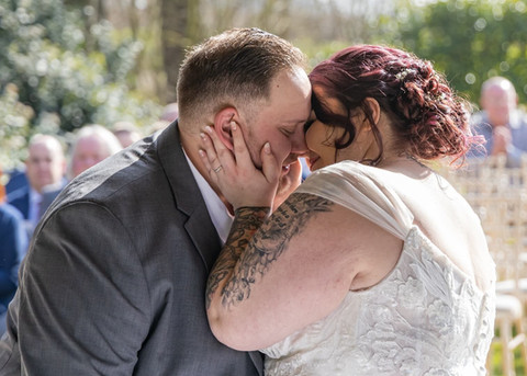 Bride and groom about to share their first kiss during their outdoor wedding ceremony at Forrester Park Golf Club in Essex