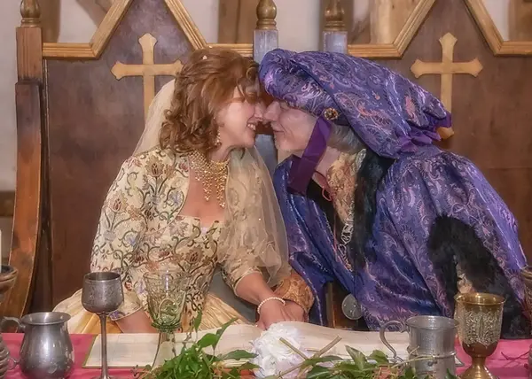 Medieval dressed wedding couple share a kiss at Cressing Temple Barns