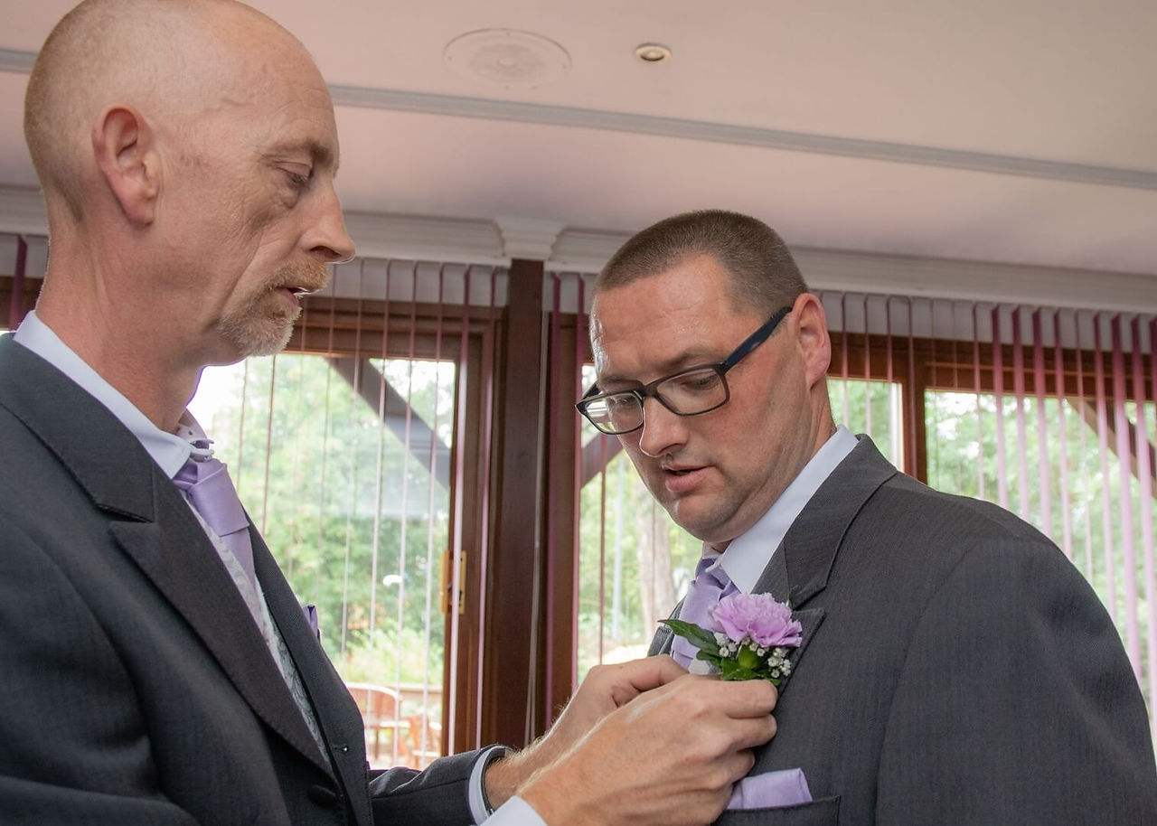 Pinning on the grooms lilac buttonhole