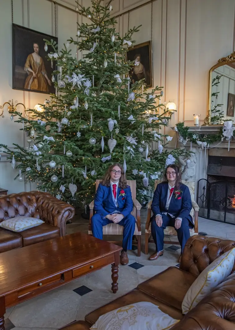 Groom and best woman by one of the Christmas Trees at Gosfield Hall