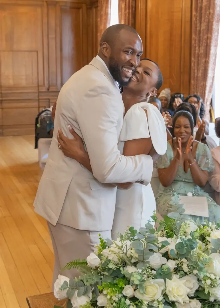 Bride and groom giggling as they hug at Braintree Town Hall
