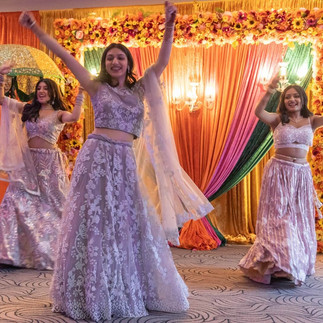 3 Indian ladies in saris performing at a reception party