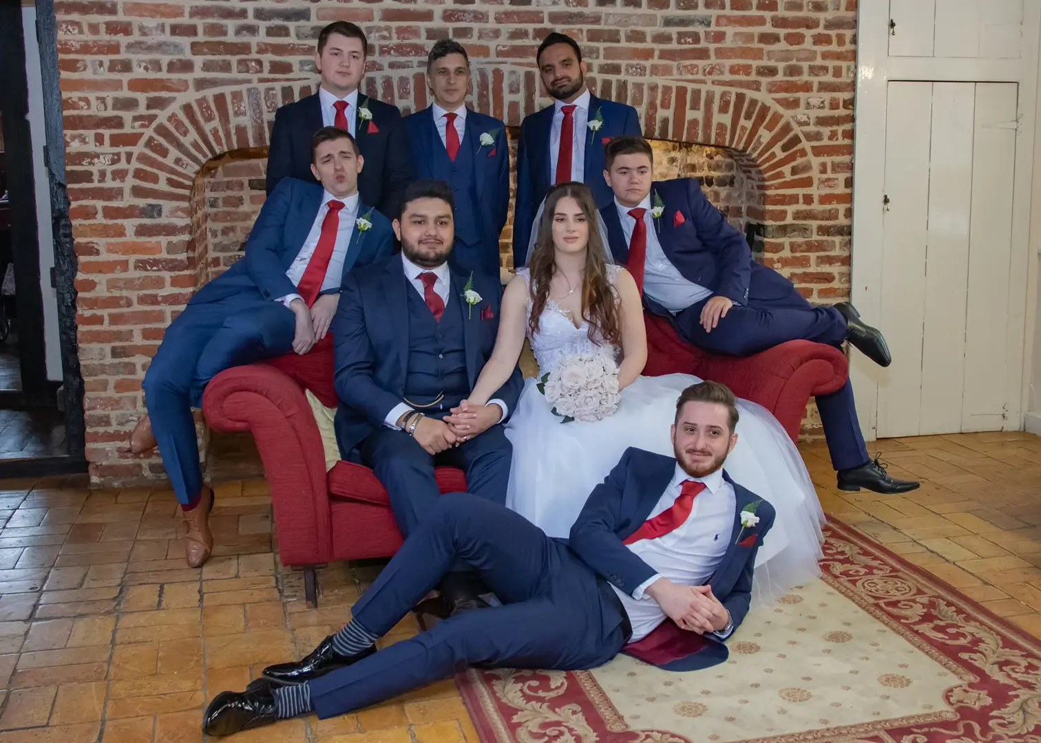 Bride and grooms party fun photo by the fireplace at Leez Priory