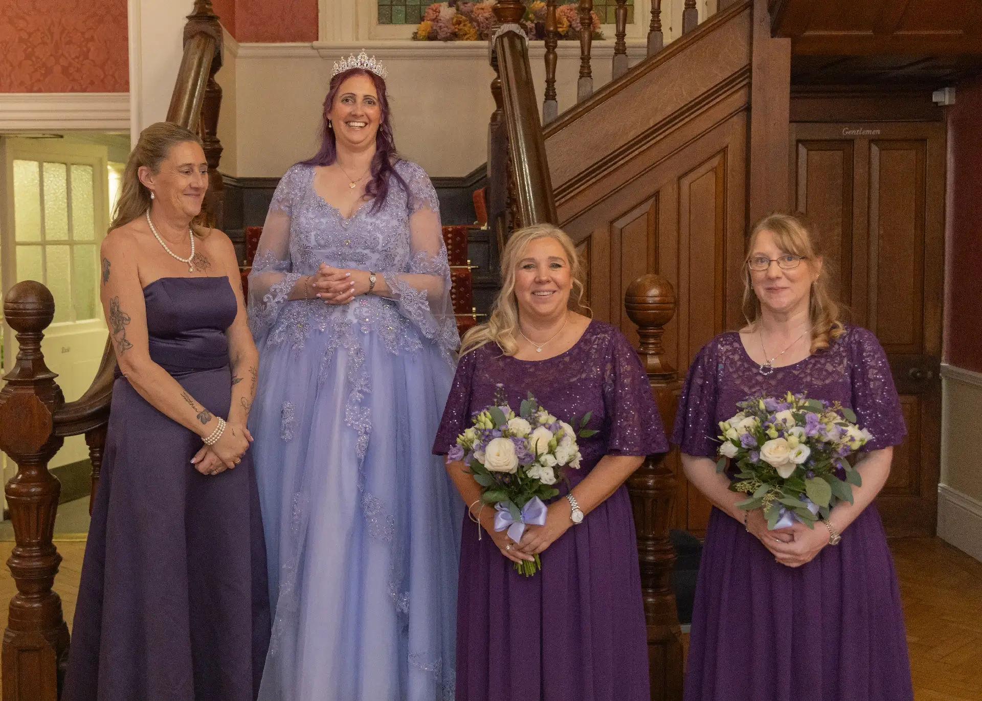 Bridal party in purple and lilac on the staircase at Langtons House