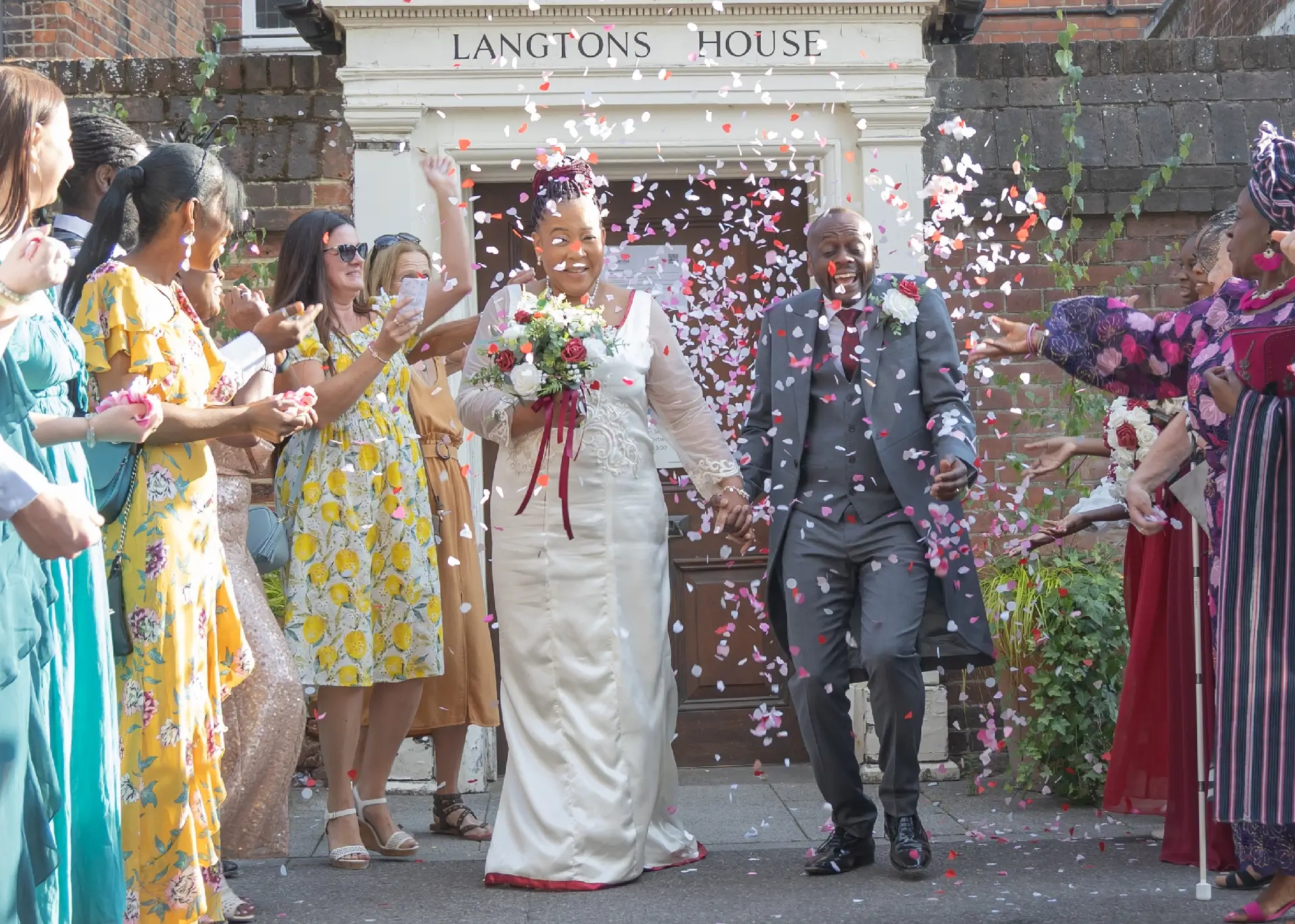 Bride and groom enjoying their confetti moment at Langtons House