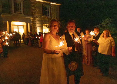Bride and groom have fun with sparklers at The Fennes