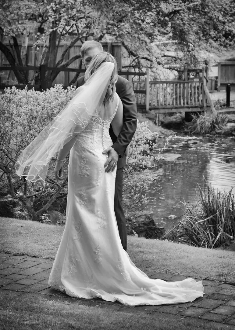 Bride and groom share a kiss outdoors between rain showers