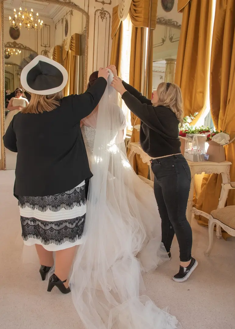 Mum helps her daughter with her wedding veil at Gosfield Hall