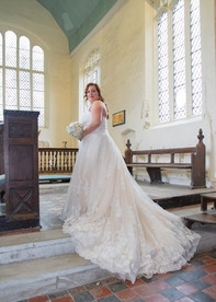 Bride looking back at the camera inside the church showing off her dress and train