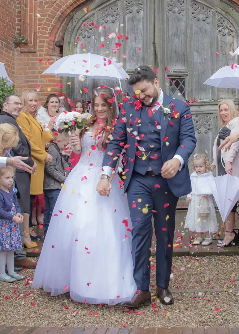 Wedding confetti at Leez priory in the rain with white umbrellas