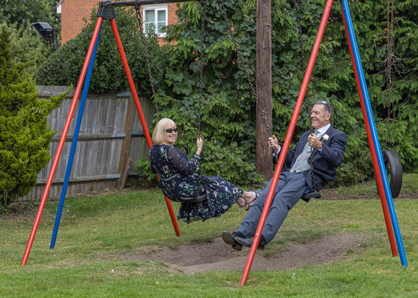 Guests playing on the swings at an Essex wedding reception