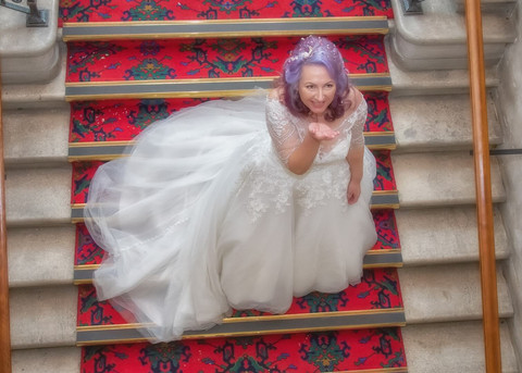 Bride on the staircase at Braintree Town Hall blowing a kiss