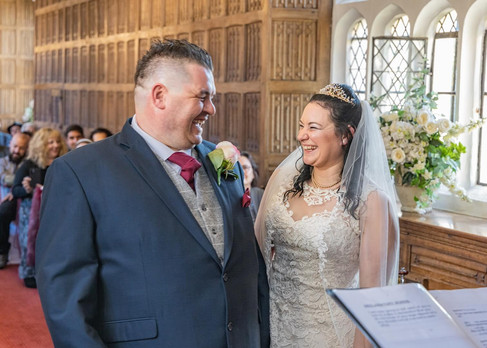 Bride and groom laughing during their indoor ceremony at Gosfield Hall