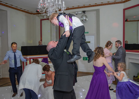 Groom having fun with young guest on the dancefloor at Gosfield Hall