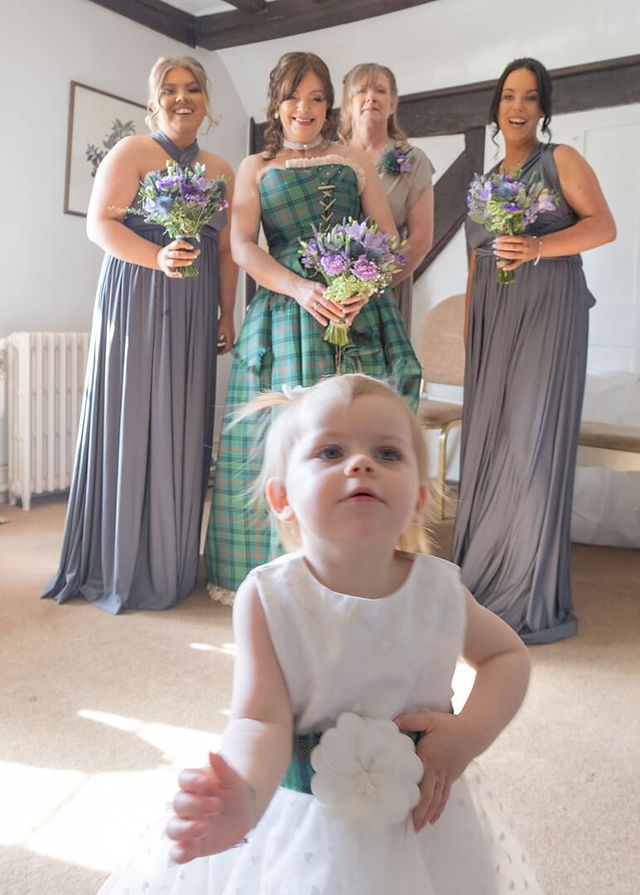 Flower girl steals the show whilst photographing the bridal party at Prested Hall in Essex