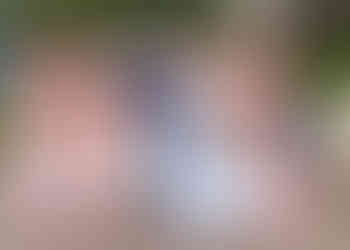 Bride with pastel teardrop bouquet stands with flower girls in white and bridesmaids in soft pink