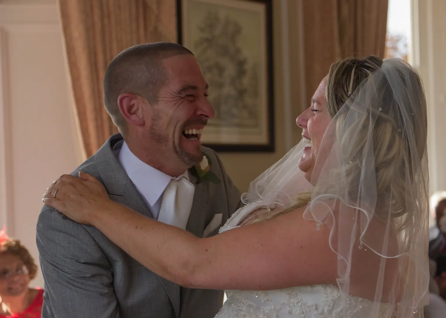 Bride and groom giggling together during wedding ceremony at Wivenhoe House