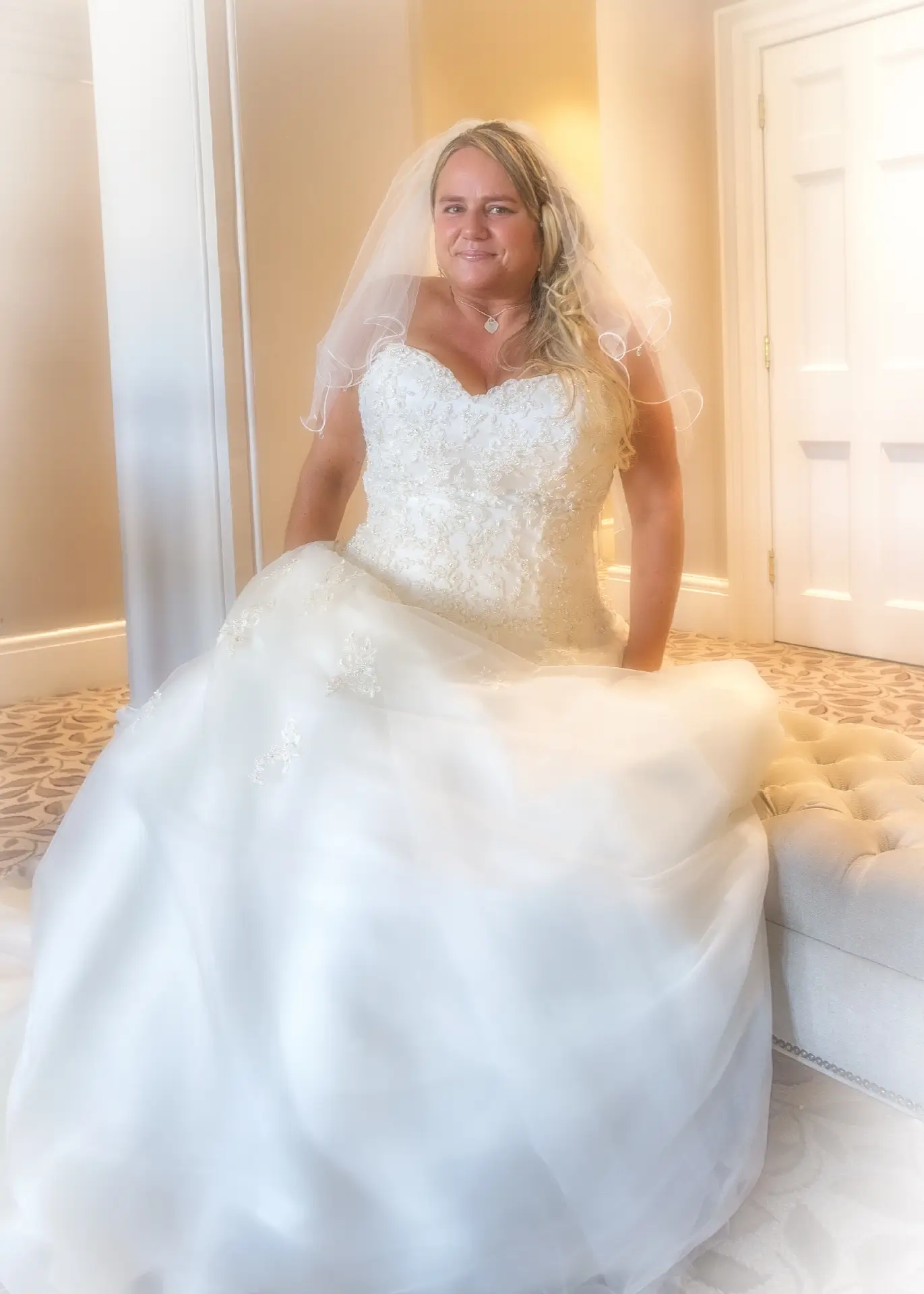 Bride sits on the chaise longue at Wivenhoe House