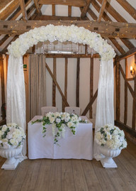 White drape and flower arch at Little Channels