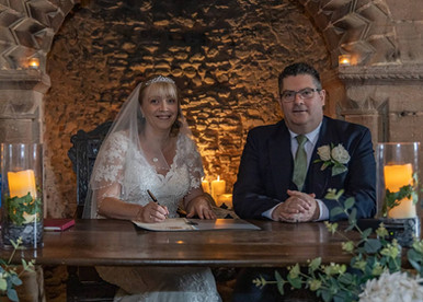 Bride and groom inside Hedingham Castle by candlelight