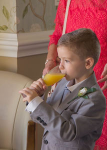 Young edding guest with glass of orange juice instead of champagne