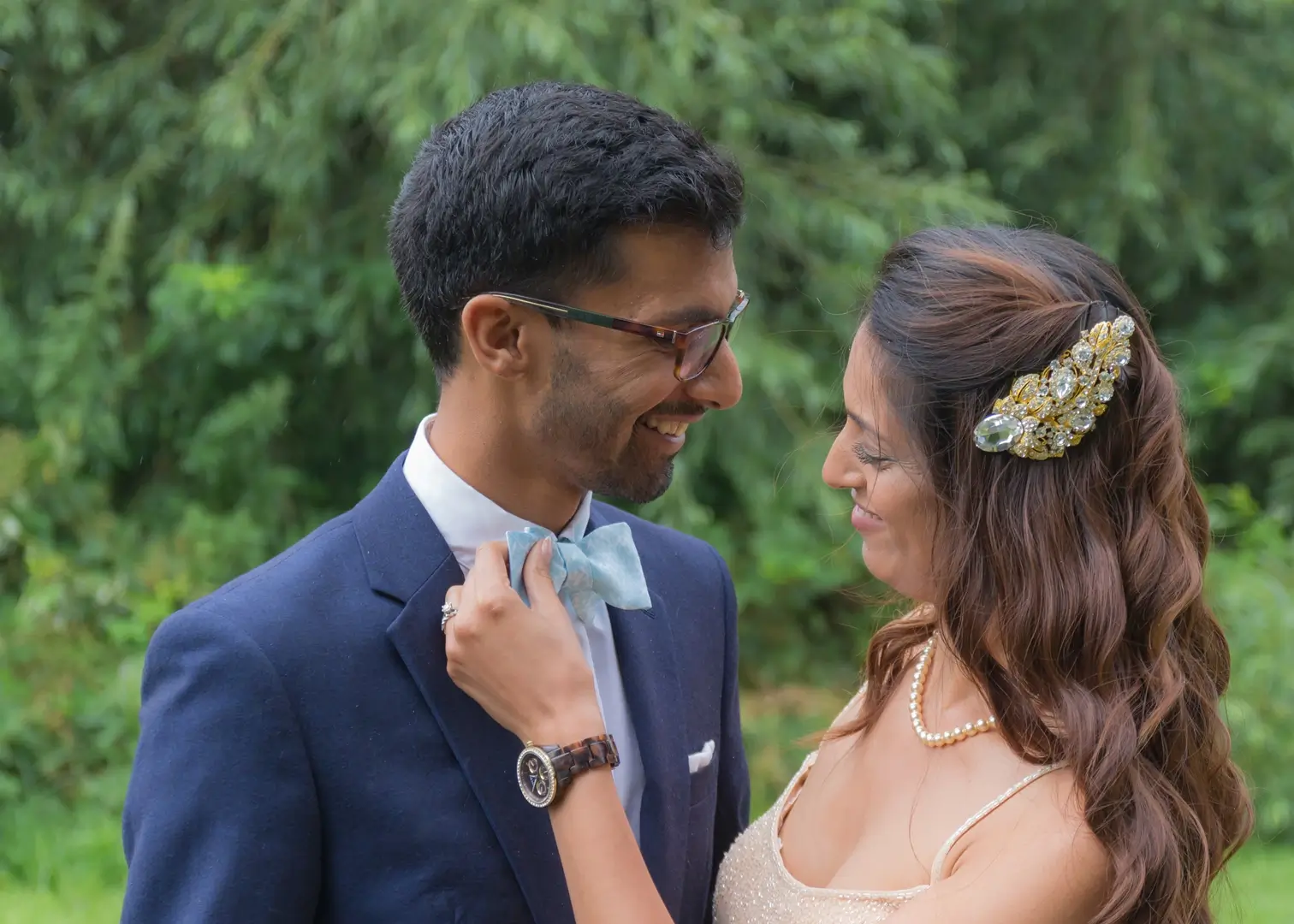 Bride adjusts grooms bowtie in a relaxed moment