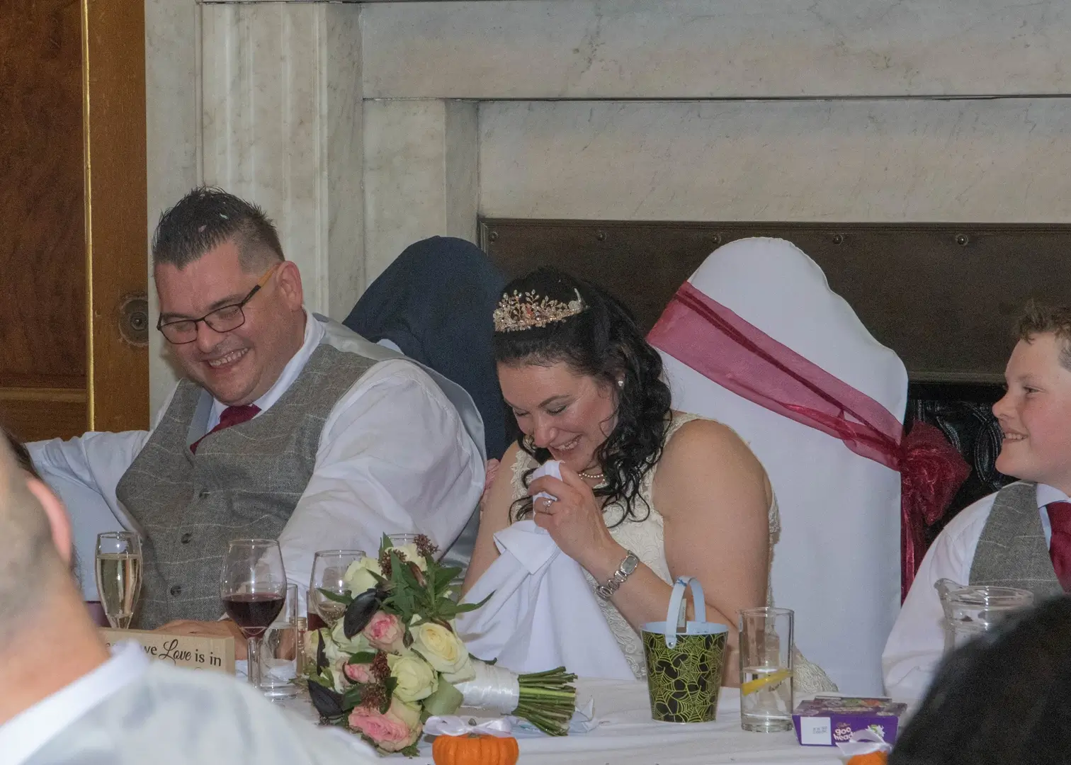Couple giggling during the speeches at their Gosfield Hall wedding
