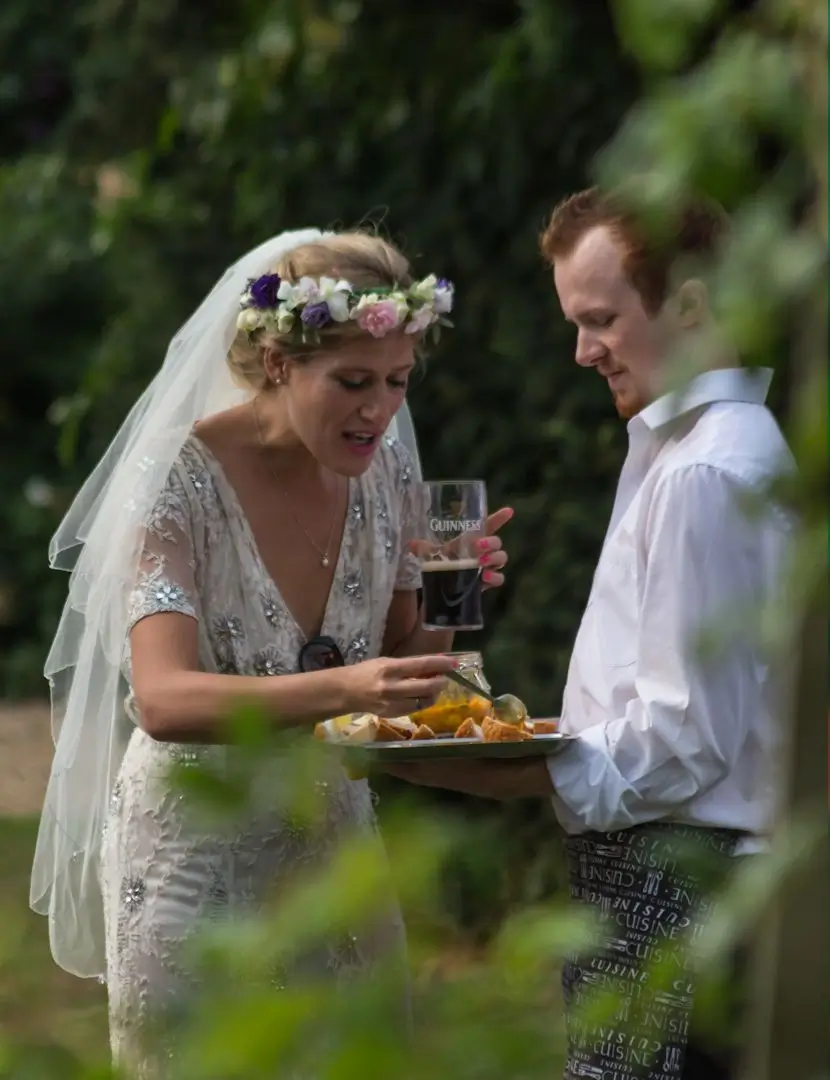 Bride helping herself to a canape at her Great Lodge Bardfield wedding