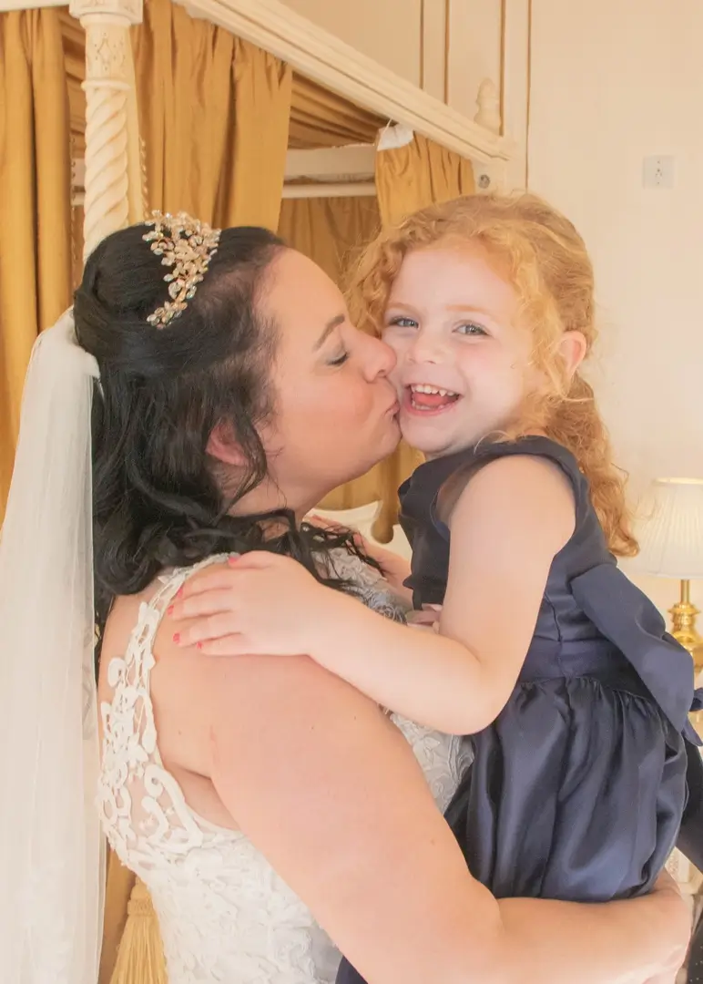 Bride hugs her niece before her wedding at Gosfield Hall