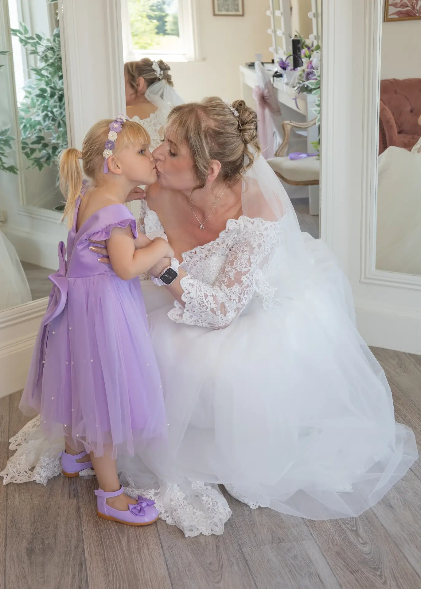 Bride kisses her grand daughter before the wedding ceremony at The Fennes