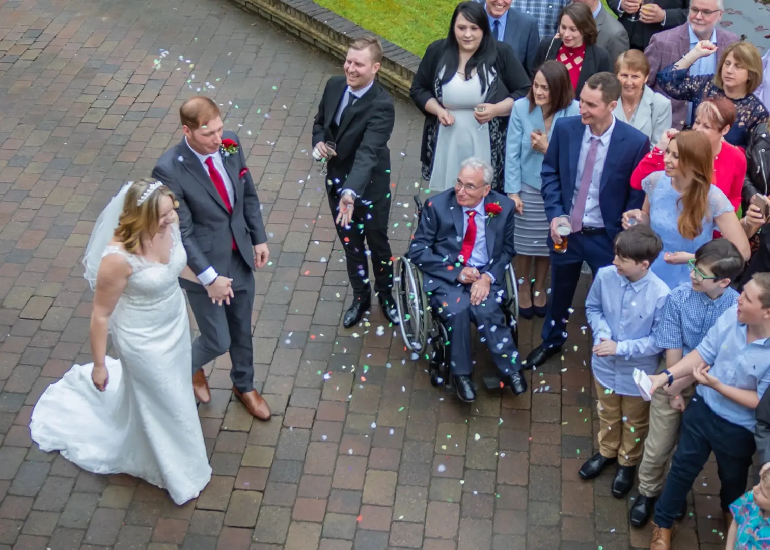 Bride and groom do a quick confetti walk between rain showers