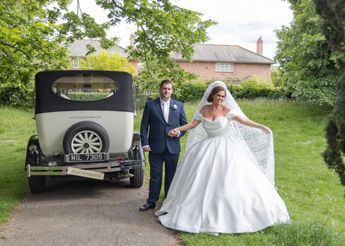 Bride an groom with vintage wedding car at Silver End Memorial Gardens in Essex