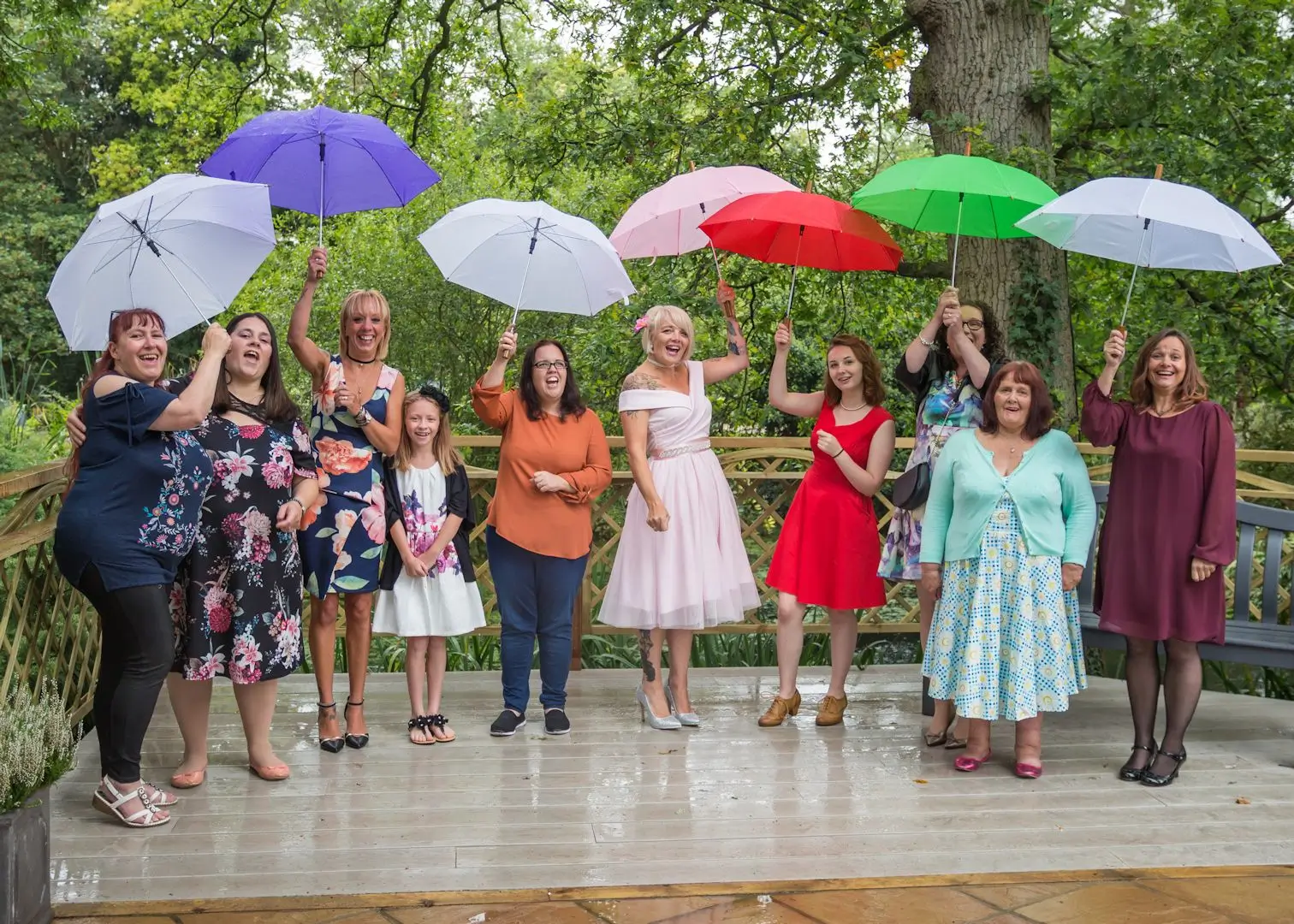Wedding party have fun in the rain with umbrellas at Ivy Hill Hotel, Margaretting