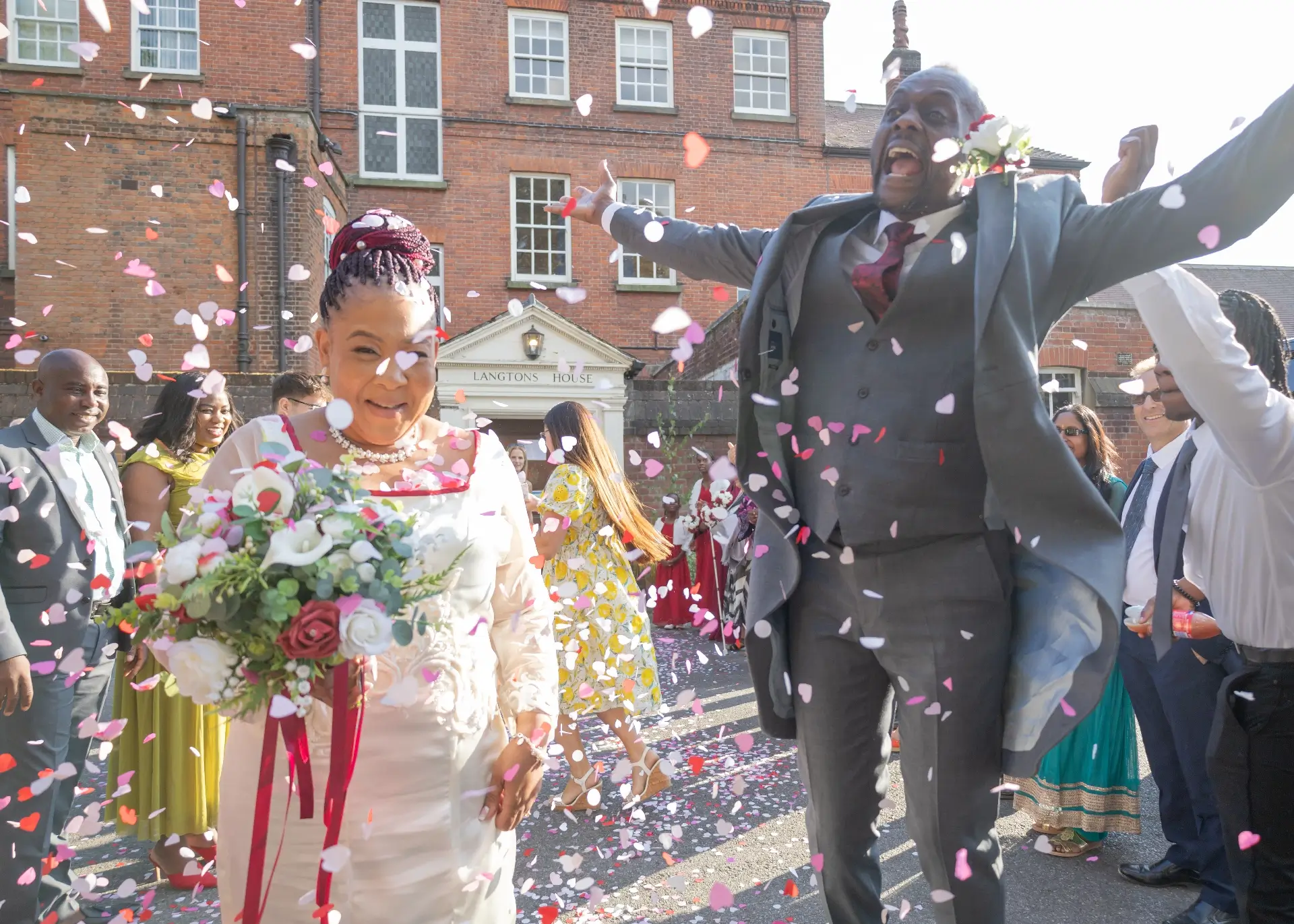 Groom jumps for joy during the wedding confetti at Langtons House
