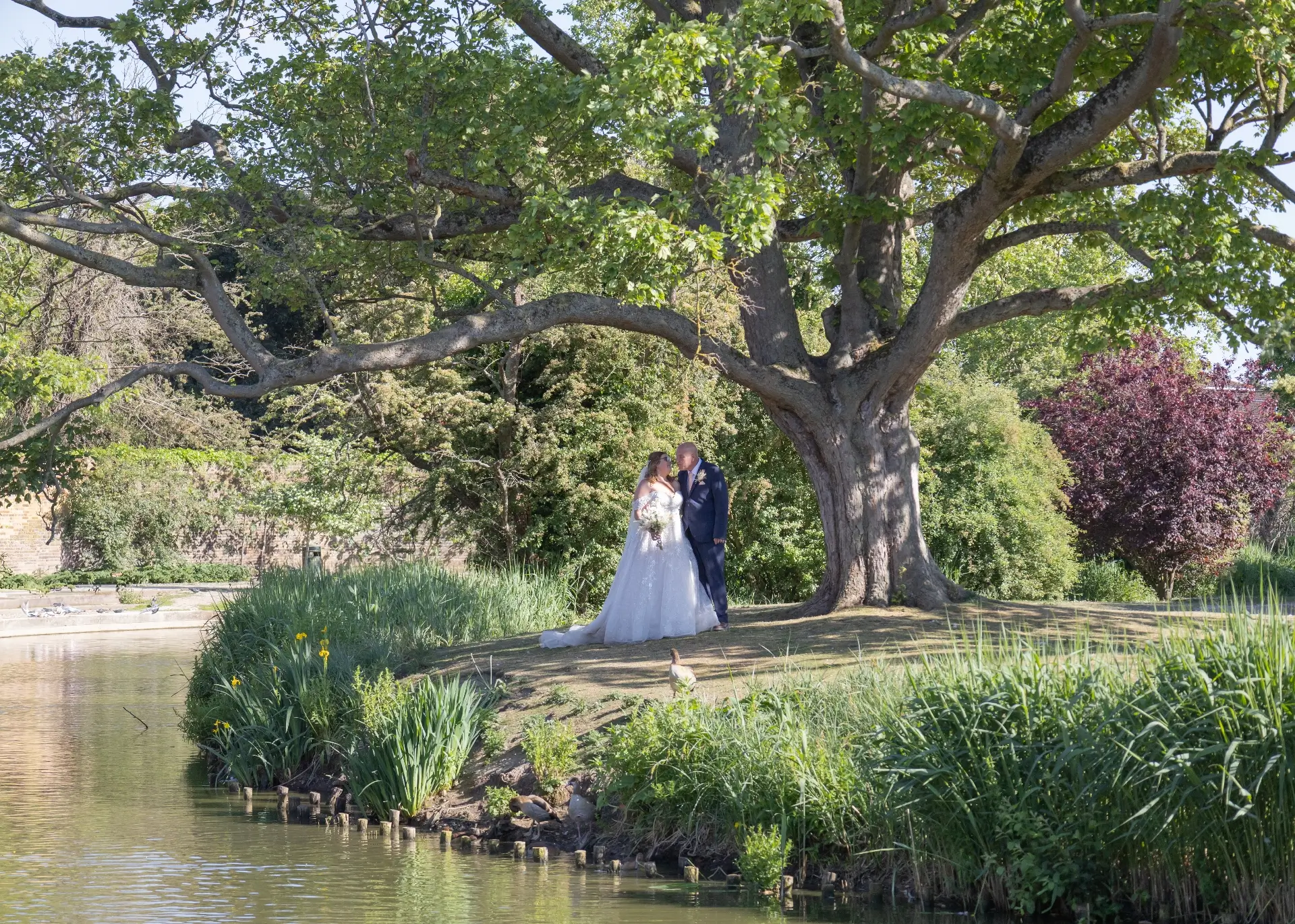 Bride and groom by the lake at Langtons House