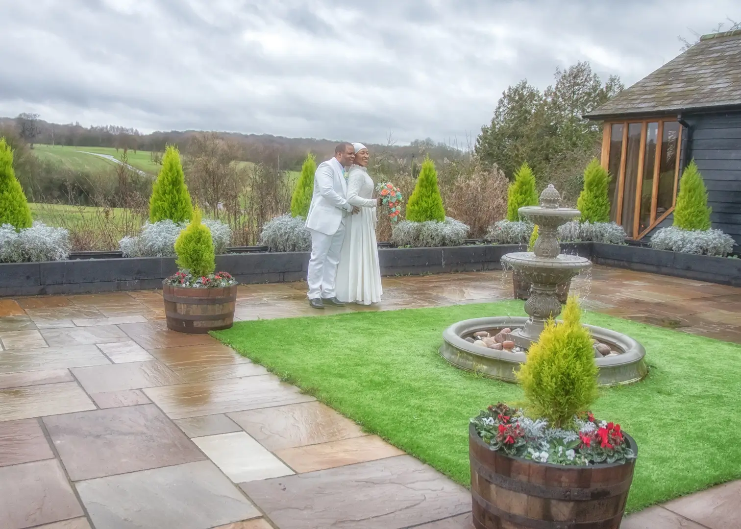 Bride and groom on the private terrace at Crondon Park just after a rain shower