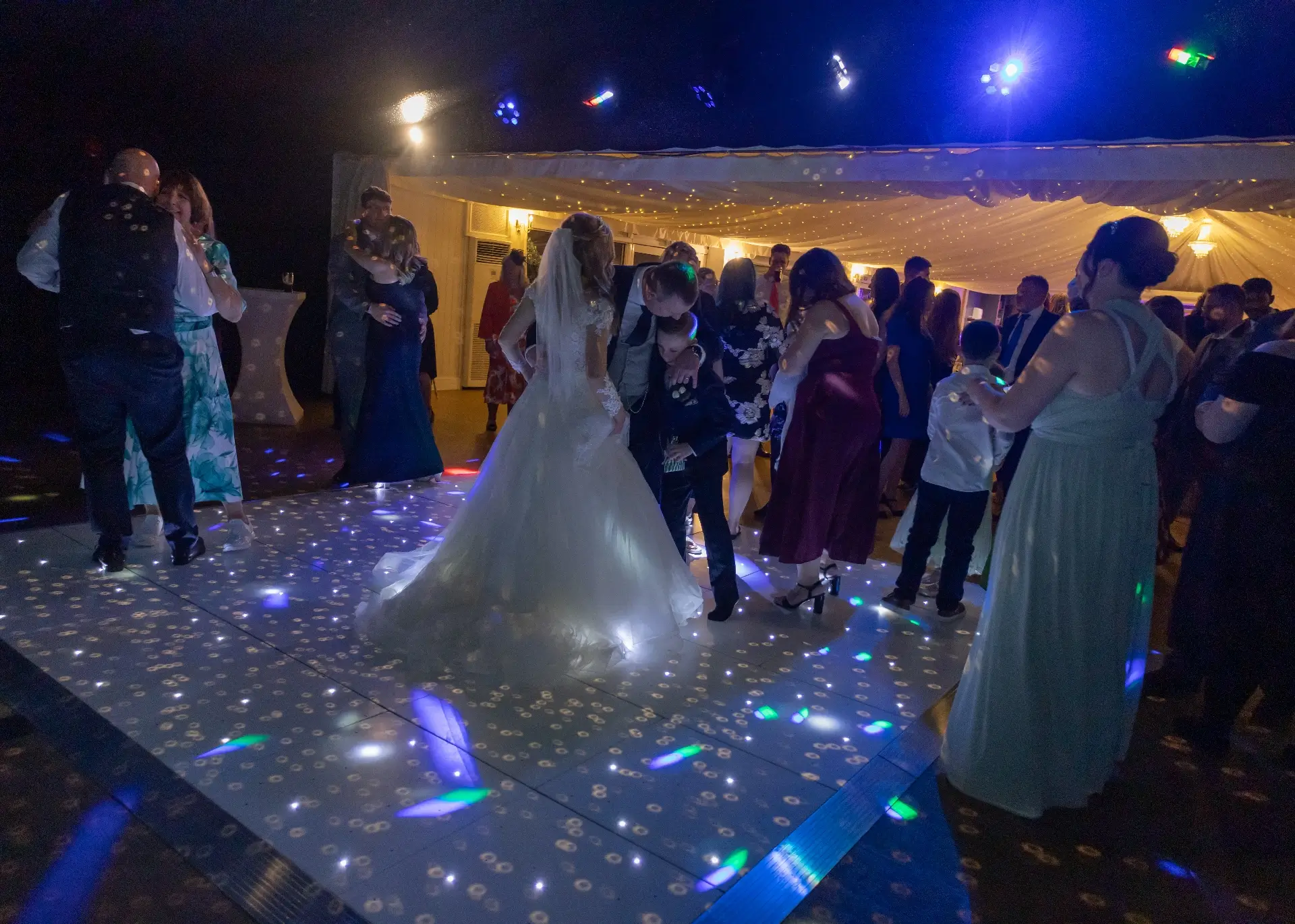 Bride and groom with their son on the dancefloor at The Fennes