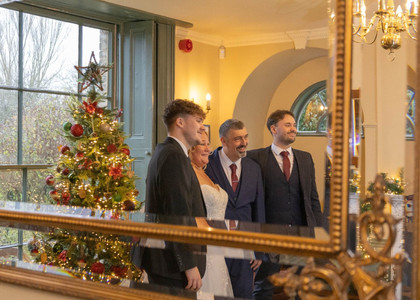 Bride and groom with sons reflected in a mirror at The Fennes
