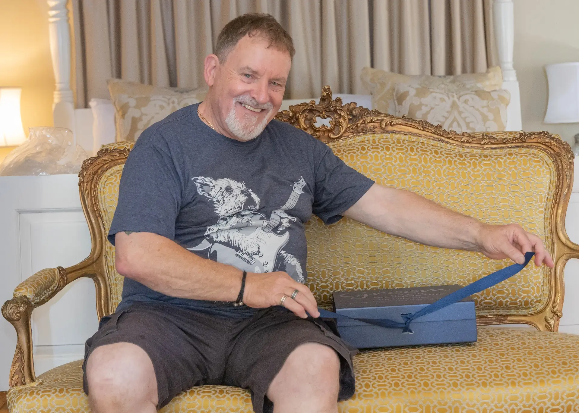 Groom in the honeymoon cottage opening his gift box from his bride