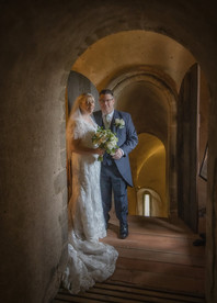 Bride and groom inside Hedingham Castle with soft golden lighting