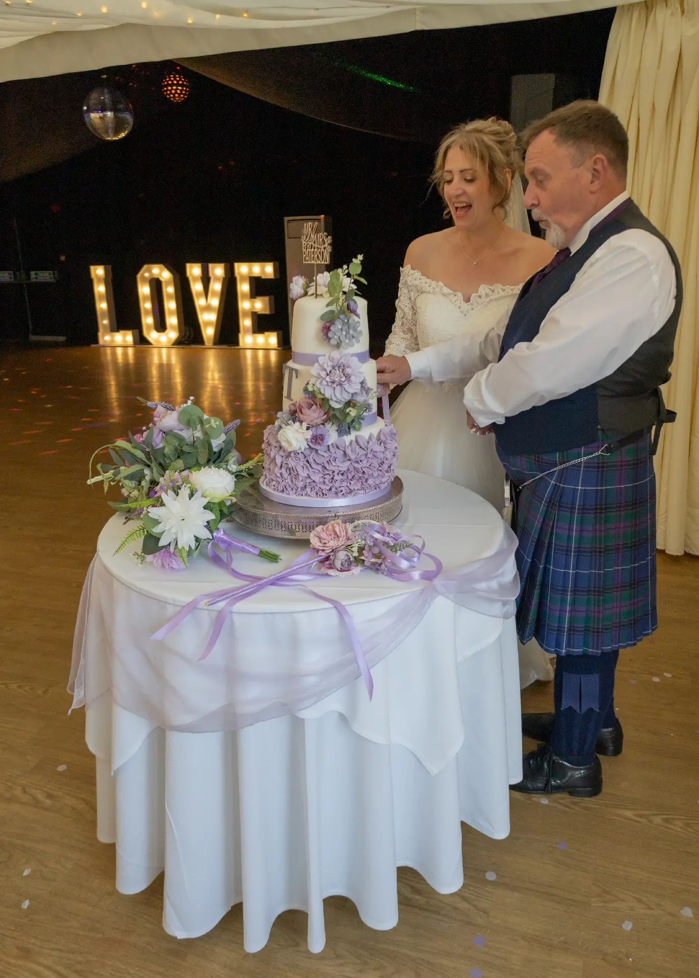 Bride and groom cutting the cake at their wedding reception at The Fennes