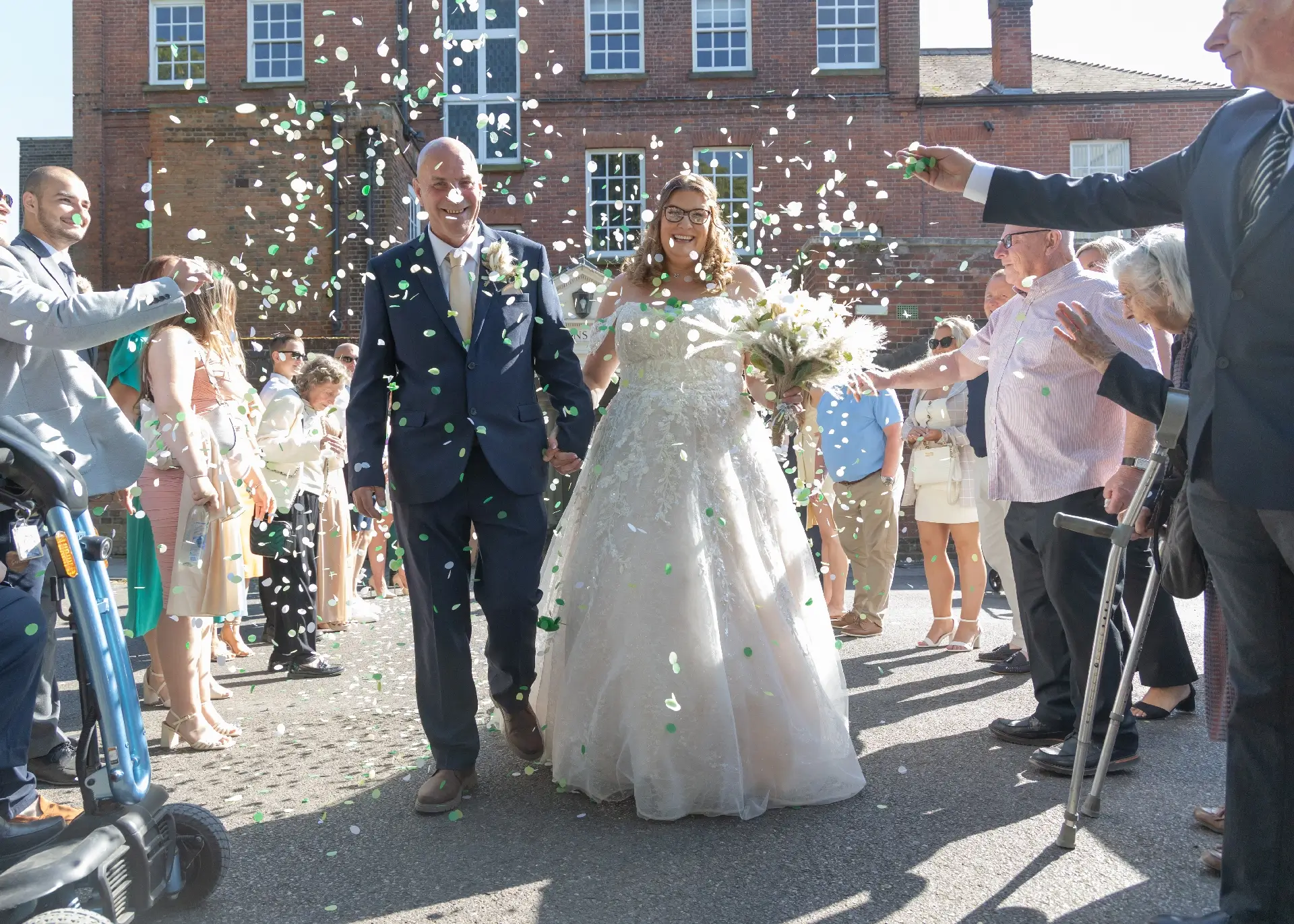 Bride and groom are showered in confetti in the sunshine at Langtons House