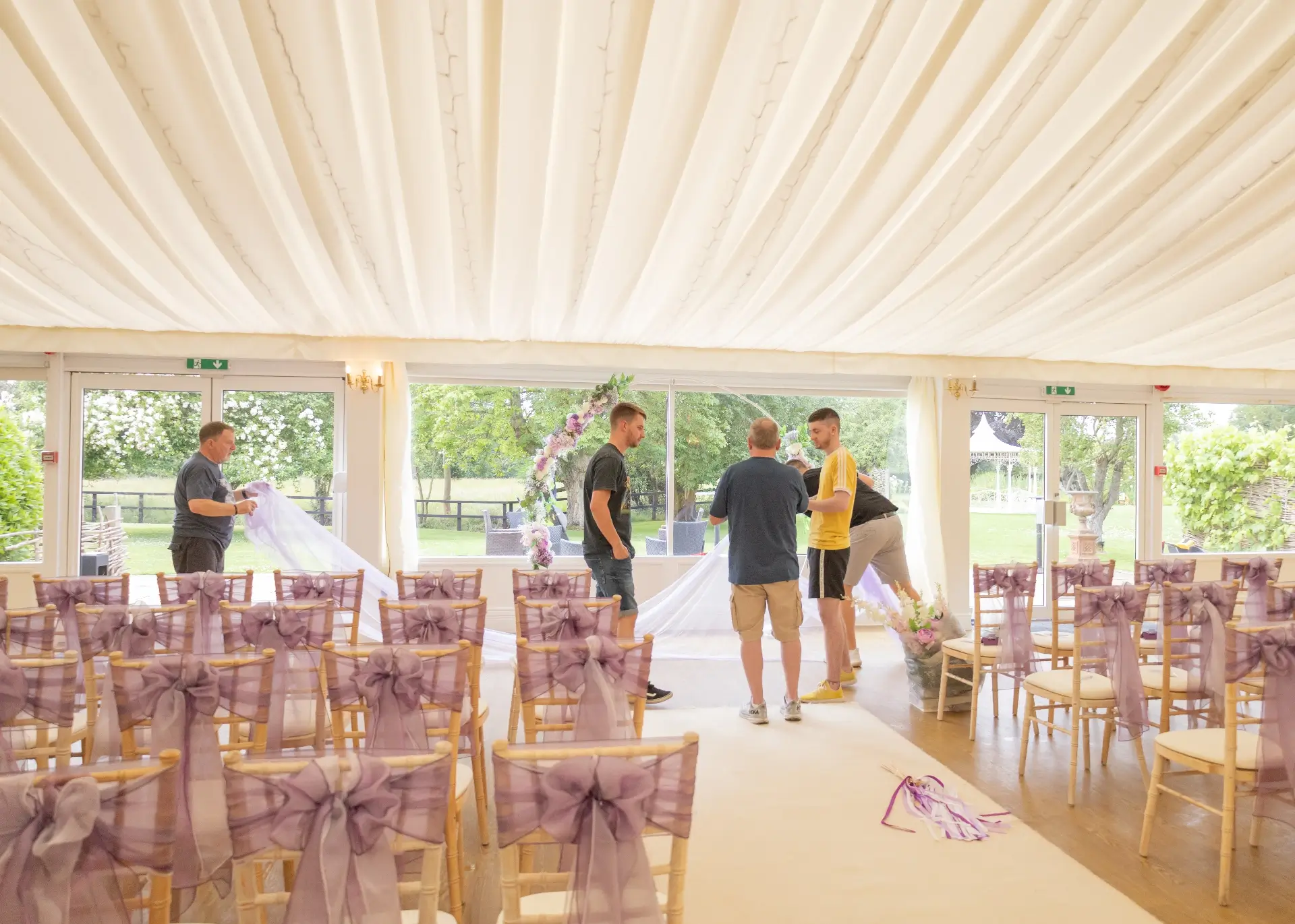 Groom and his party sorting the flower arch at The Fennes