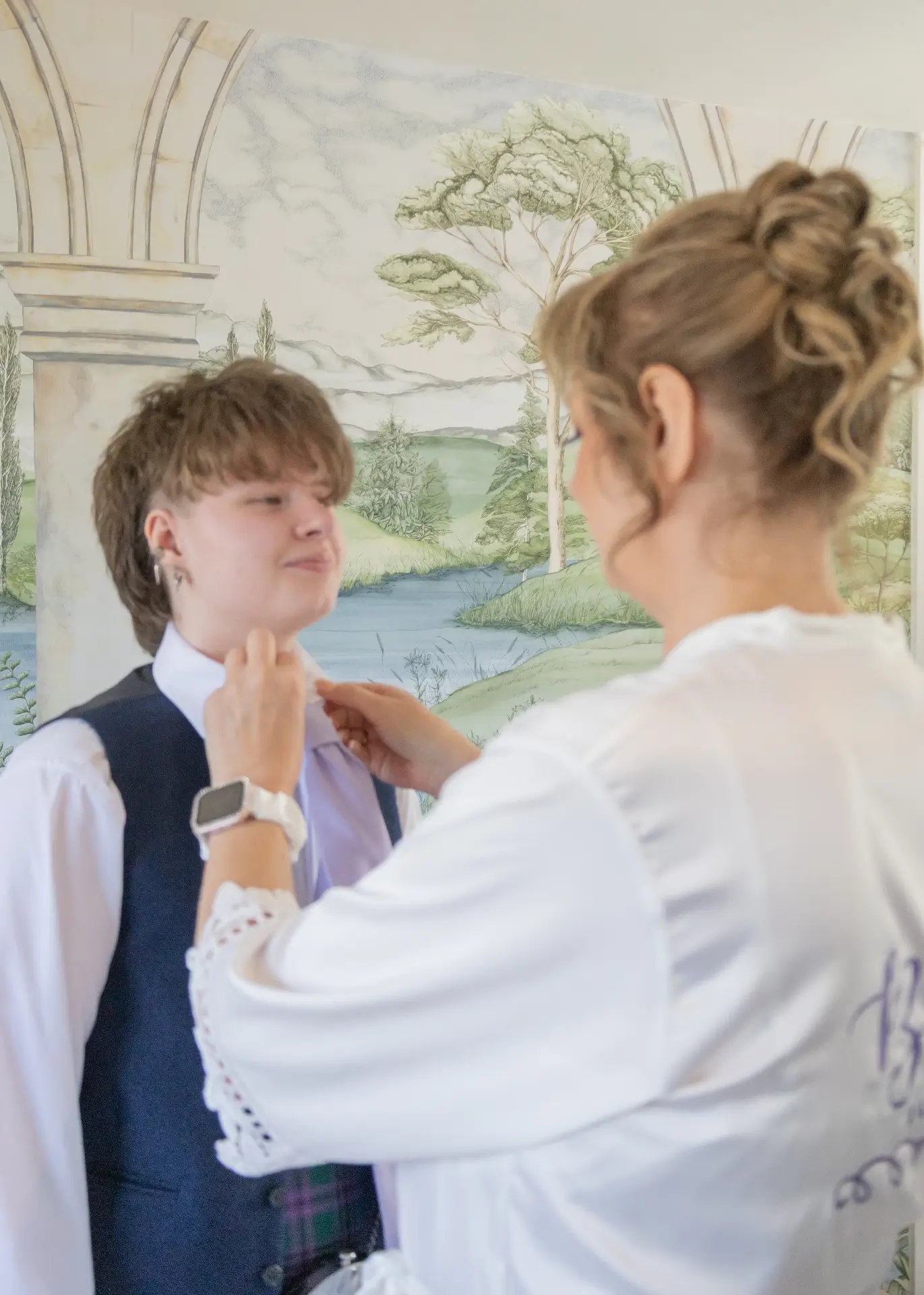 Bride sorts out a tie at The Fennes