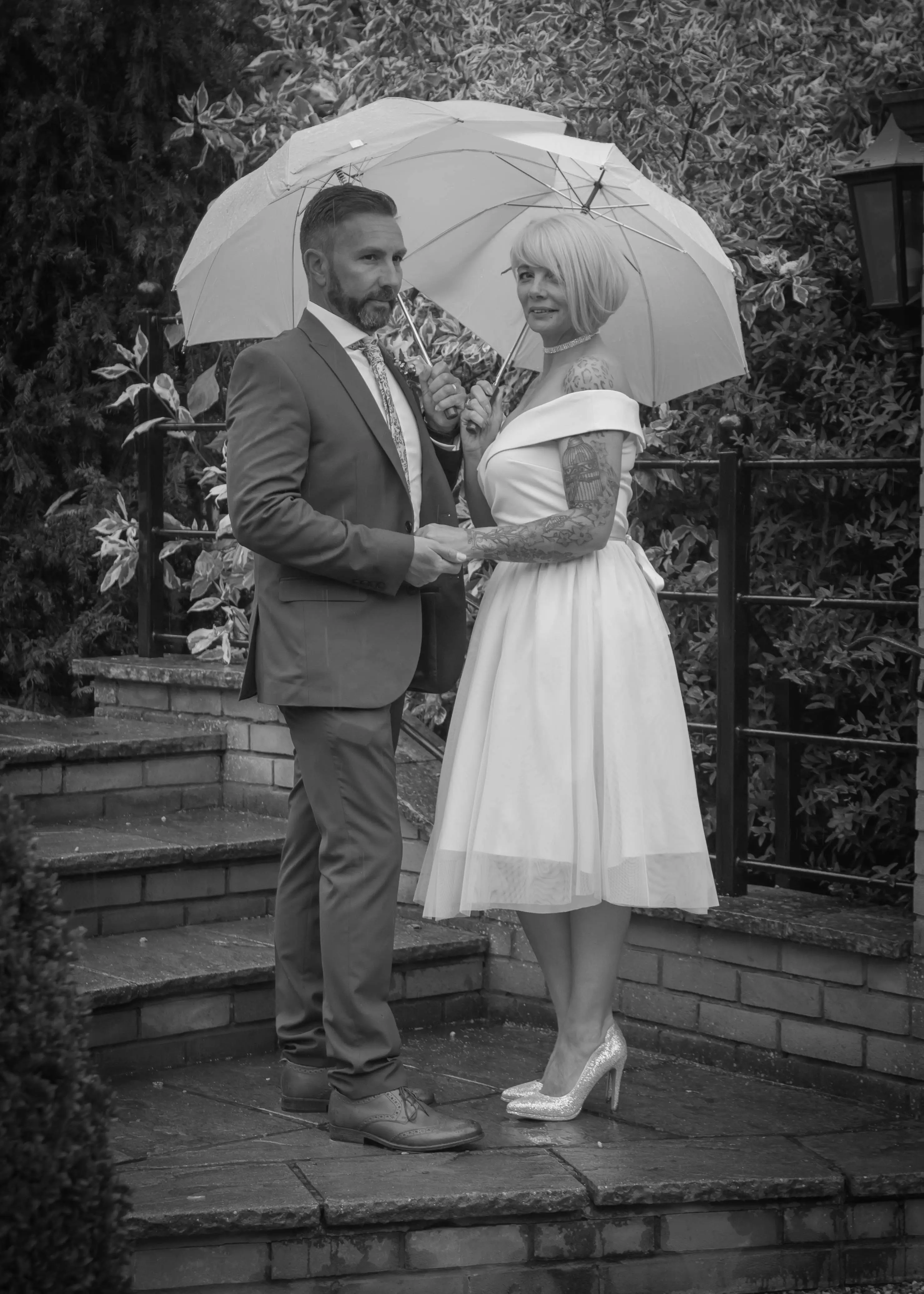Couple with umbrellas in the rain at The Ivy Hill Hotel