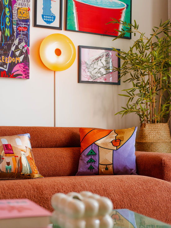Cover image: living room with terracotta sofa, bohemian gallery wall, woven rug, and vintage rattan side chair