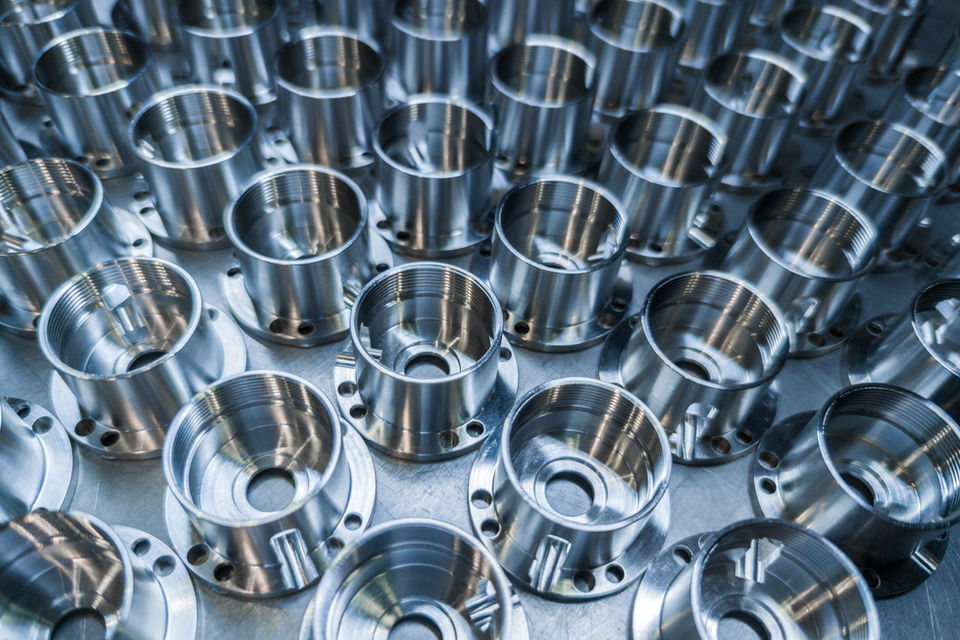 Turned parts with milled holes, staged for processing
