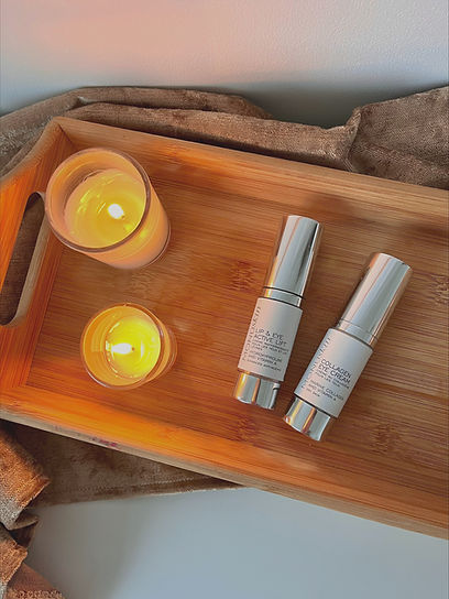 MONUSKIN's collagen eye cream and lip and eye active lift on a wooden tray with two candles