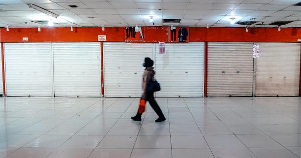 Salah seorang pekerja saat melintas ditengah deretan toko yang tutup di Blok M Mal. (Historia/Fernando Randy)
