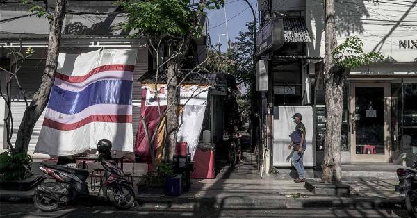 Seorang warga melintas di deretan kafe dan toko yang tutup di kawasan Kuta, Bali. (Fernando Randy/Historia.id).